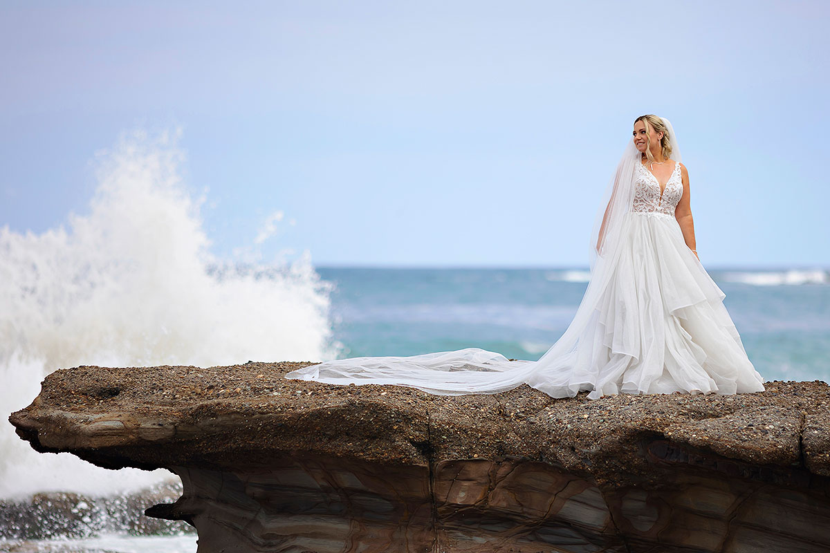 caves beach wedding bride on rocks