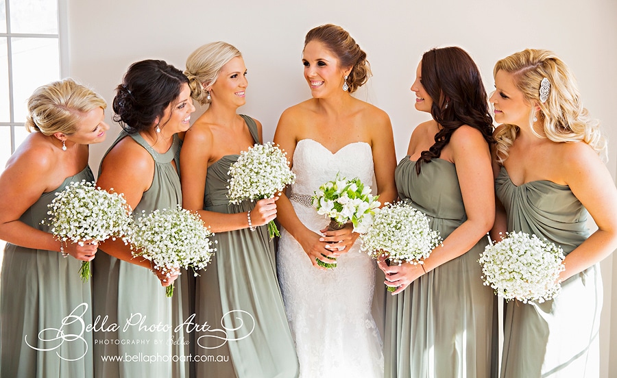 bride and bridesmaids in green dresses with baby breath bouquets